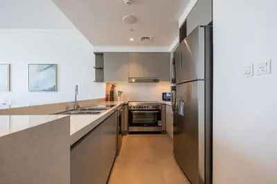 a kitchen with a stainless steel refrigerator and a sink at Spacious 3BDR with Maid Room I Creek Harbour I Creek Gate Tower 2 in Dubai