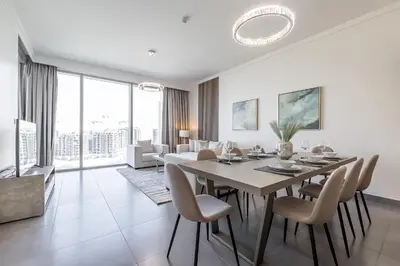 a white dining room with a table and chairs at Spacious 3BDR with Maid Room I Creek Harbour I Creek Gate Tower 2 in Dubai