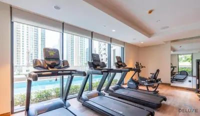a gym with cardio machines and a swimming pool at Plush 1BR at Act One Act Two Tower 2 Downtown Dubai by Deluxe Holiday Homes in Dubai