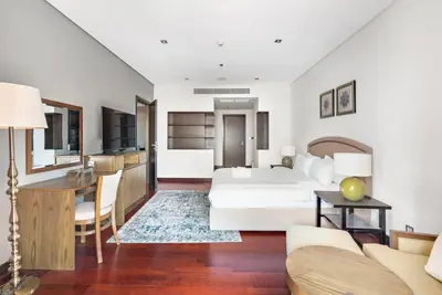 a bedroom with a bed and a table and a desk at StoneTree - Anantara South Residences 2 BR - Palm Jumeirah in Dubai