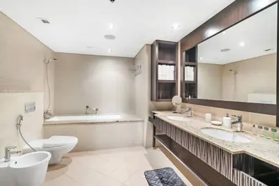a bathroom with two sinks and a toilet and a mirror at StoneTree - Anantara South Residences 2 BR - Palm Jumeirah in Dubai