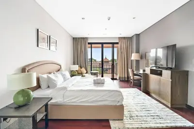 a bedroom with a bed and a desk and a kitchen at StoneTree - Anantara South Residences 2 BR - Palm Jumeirah in Dubai