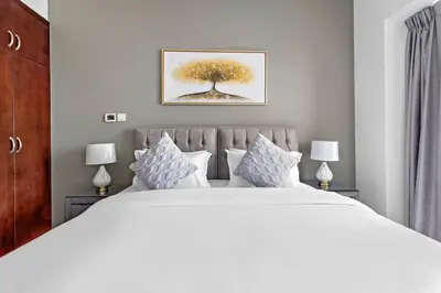 a bedroom with a large white bed with two lamps at StoneTree - Marina Tower 1BR - Dubai Marina in Dubai