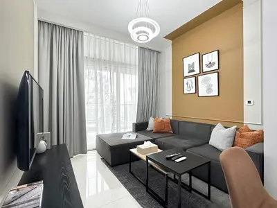 a living room with a black couch and a tv at Trophy - Cityscape Posh Suite in Dubai