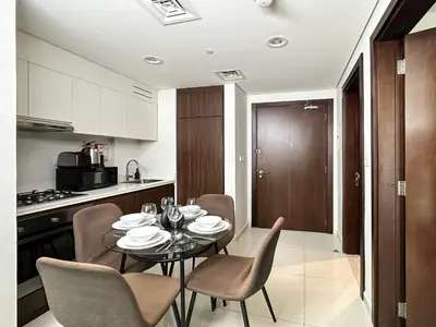 a dining room with a table and chairs in a kitchen at Trophy - Cityscape Posh Suite in Dubai