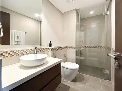 a bathroom with a sink and a toilet and a shower at Trophy - Cityscape Posh Suite in Dubai