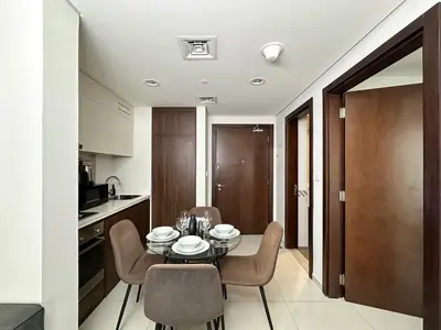 a kitchen and dining room with a table and chairs at Trophy - Cityscape Posh Suite in Dubai