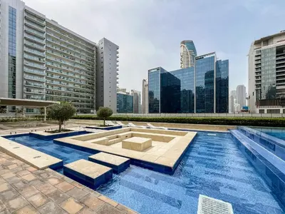 a pool in the middle of a city with tall buildings at Trophy - Cityscape Posh Suite in Dubai