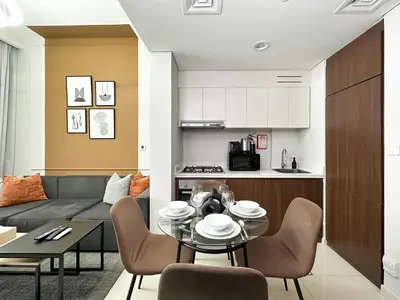 a living room with a couch and a table and chairs at Trophy - Cityscape Posh Suite in Dubai