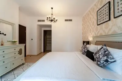 a bedroom with a large white bed and a chandelier at INA HOMES - Residences Tower 1 Upper Floor in Dubai