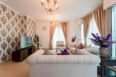 a living room with a white couch and a tv at INA HOMES - Residences Tower 1 Upper Floor in Dubai