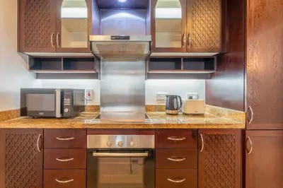 a kitchen with a microwave oven and a stove at INA HOMES - Residences Tower 1 Upper Floor in Dubai