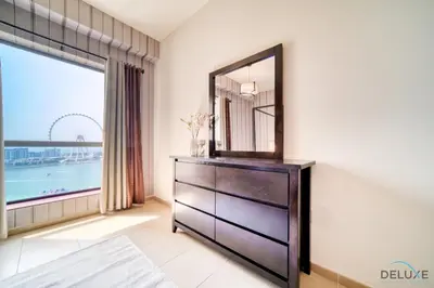 a bedroom with a dresser and a mirror at Pristine 2BR at Bahar 2 JBR by Deluxe Holiday Homes in Dubai
