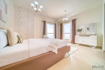 a bedroom with a large white bed and windows at Pristine 2BR at Bahar 2 JBR by Deluxe Holiday Homes in Dubai