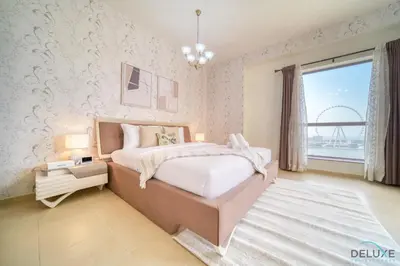 a bedroom with a large bed and a large window at Pristine 2BR at Bahar 2 JBR by Deluxe Holiday Homes in Dubai
