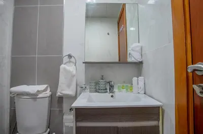 a bathroom with a sink and a toilet and a mirror at Modern Silicon Oasis Studio Near Academic City in Dubai