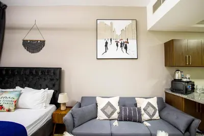 a living room with a bed and a couch at Modern Silicon Oasis Studio Near Academic City in Dubai