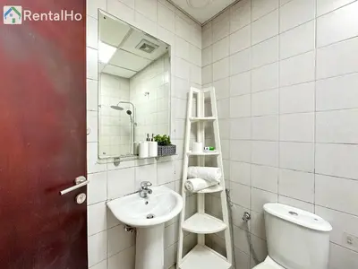 a bathroom with a sink and a toilet and a mirror at Big Studio w/ Balcony and easy access to the Beach in Dubai