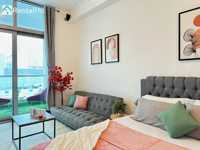 a living room with a bed and a couch at Big Studio w/ Balcony and easy access to the Beach in Dubai
