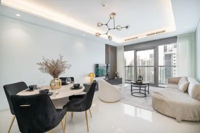 a living room with a table and chairs and a couch at Stylish 2Bedroom w infinity pool on the 64th floor in Dubai