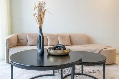 a coffee table with a vase and a bowl on it at Stylish 2Bedroom w infinity pool on the 64th floor in Dubai