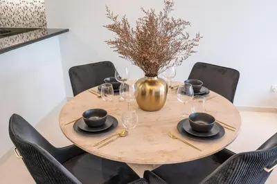 a wooden table with wine glasses and a vase at Stylish 2Bedroom w infinity pool on the 64th floor in Dubai
