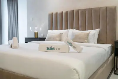 a large white bed with two boxes on it at Stylish 2Bedroom w infinity pool on the 64th floor in Dubai