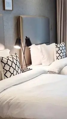 a bedroom with two beds with white sheets and pillows at Luxury Paramount Hotel Apt B666 in Dubai