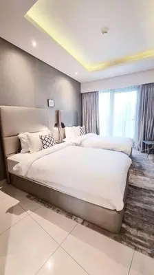 a large bedroom with two beds and a window at Luxury Paramount Hotel Apt B666 in Dubai