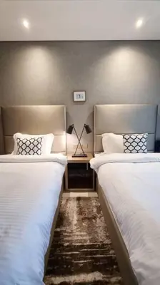 a bedroom with two beds and a table with a lamp at Luxury Paramount Hotel Apt B666 in Dubai