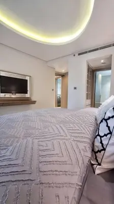 a bedroom with a large bed with a tv on the wall at Luxury Paramount Hotel Apt D576 in Dubai