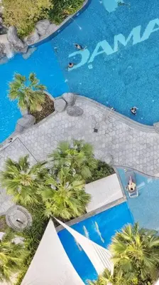 an overhead view of a swimming pool with palm trees at Luxury Paramount Hotel Apt D576 in Dubai