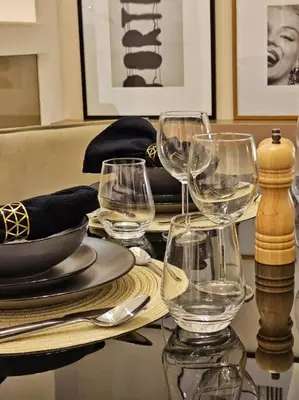 a table with wine glasses and plates on it at Luxury Paramount Hotel Apt D576 in Dubai