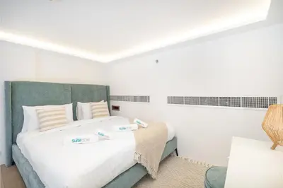a bedroom with a large white bed with two certificates on it at Relax & Recharge Studio Loft with hanging net in Dubai