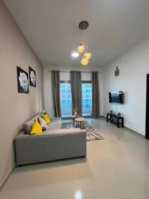a living room with a couch and a tv at Holiday Rental in Dubai