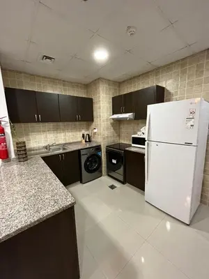 a kitchen with a white refrigerator and a stove at Holiday Rental in Dubai