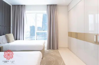 a hotel room with two beds and a window at Alashrafia Saray- Waterfront 3 BDR apartment Business Bay in Dubai