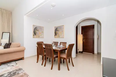 a dining room with a table and chairs and a couch at Dubai Marina,JBR -Luxurious 2 BR King Suite in Dubai