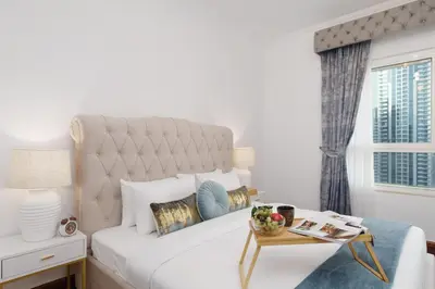 a white bedroom with a large bed and a window at Maison Privee - Dreamy Apt with Jaw-Dropping Marina Views in Dubai