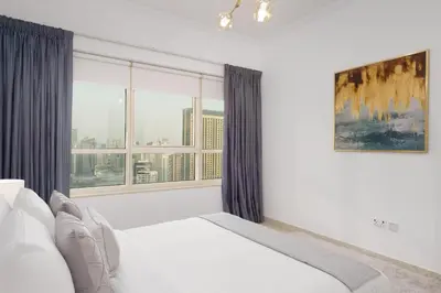 a bedroom with a bed and a large window at Maison Privee - Dreamy Apt with Jaw-Dropping Marina Views in Dubai
