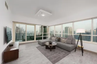 a living room with a couch and large windows at Maison Privee - Dreamy Apt with Jaw-Dropping Marina Views in Dubai