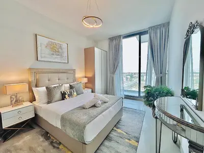 a bedroom with a large bed and a window at Modern 1 BR Apartment at JVC Dubai Prime Location! in Dubai