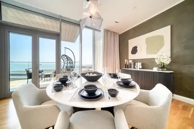 a dining room with a table and chairs with a view of the ocean at Bluewaters Residences - Sea View, Bluewaters Island - Mint Stay in Dubai