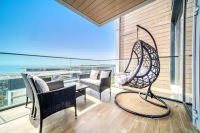 a porch with chairs and a swing on a balcony at Bluewaters Residences - Sea View, Bluewaters Island - Mint Stay in Dubai