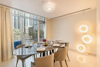 a dining room with a table and chairs and a large window at Chic 2BR Duplex, Huge Balcony High-End Furniture - Allsopp&Allsopp in Dubai