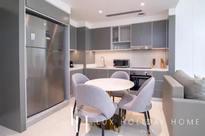 a kitchen with a table and chairs and a refrigerator at LUX The Luxury Sunrise Beachfront Suite 2 in Dubai