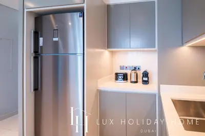 a kitchen with a stainless steel refrigerator in a kitchen at LUX The Luxury Sunrise Beachfront Suite 2 in Dubai