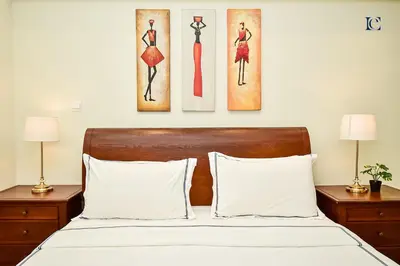 a bedroom with a bed with three paintings on the wall at Luxury Escapes - Modern Studio Apt - Steps to Metro, Marina Mall and JBR Beach - Marina Pearl in Dubai