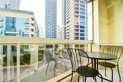 a balcony with a table and chairs and buildings at Luxury Escapes - Modern Studio Apt - Steps to Metro, Marina Mall and JBR Beach - Marina Pearl in Dubai