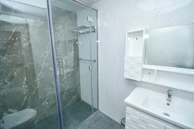 a bathroom with a glass shower and a sink at Luxury Escapes - Modern Studio Apt - Steps to Metro, Marina Mall and JBR Beach - Marina Pearl in Dubai